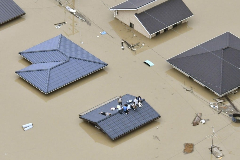 Photo taken from a Kyodo News helicopter on Saturday shows a residential area of Kurashiki, Okayama Prefecture, where homes are submerged following torrential rains that hit a wide area of western Japan. Photo: Kyodo