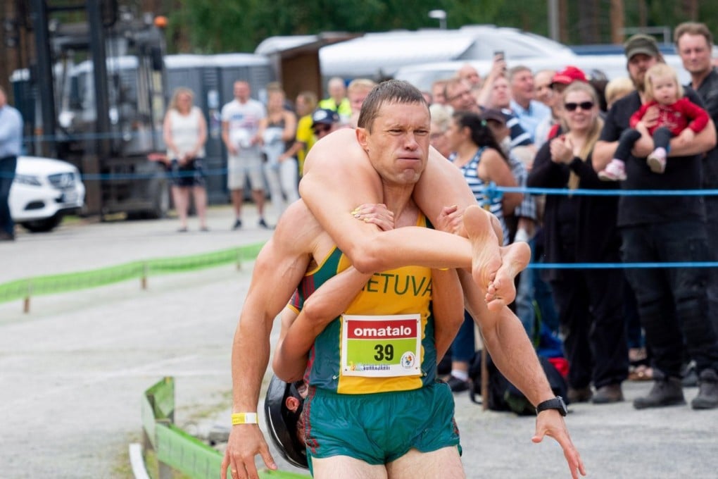 Vytautas Kirkliauskas of Lithuania carries his wife Neringa Kirkliauskiene as they compete during the Wife Carrying World Championships 2018 in Sonkajarvi, Finland. Photo: Reuters