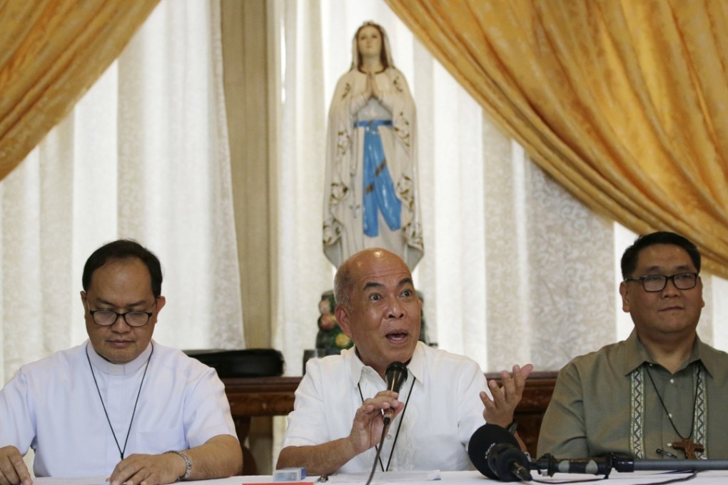 President of the Catholic Bishops’ Conference of the Philippines, Archbishop Romulo Valles (centre) speaks to the press on July 9, 2018, in Manila, Philippines. Photo: AP