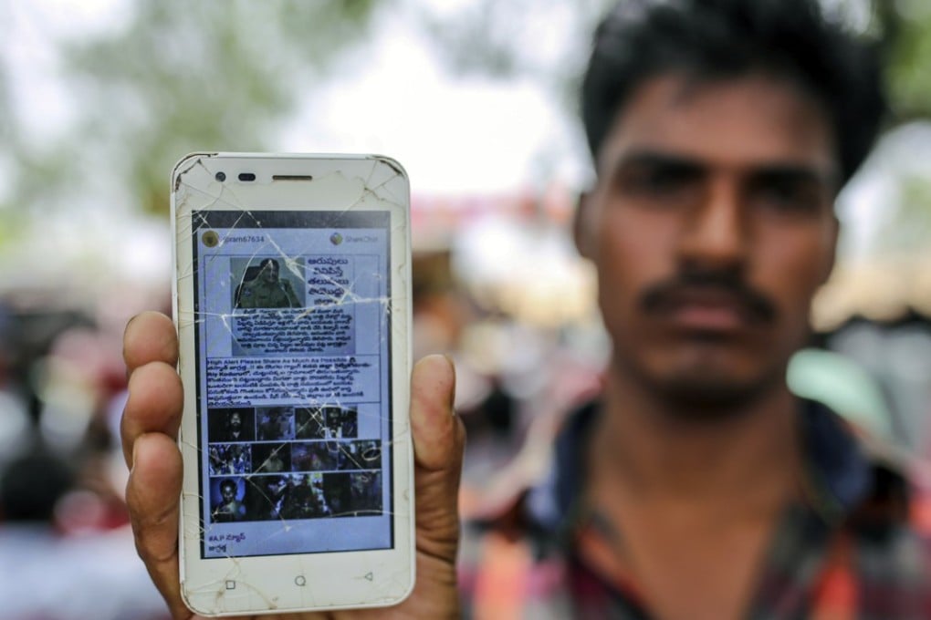 A man holds a mobile phone displaying a fake message shared on WhatsApp. Photo: Bloomberg