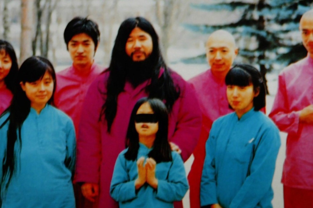An undated photo shows cult leader Shoko Asahara (centre) with his wife Tomoko (left front) and daughter Archery (centre front) along with an inner group of disciples at an unknown location. Photo: EPA