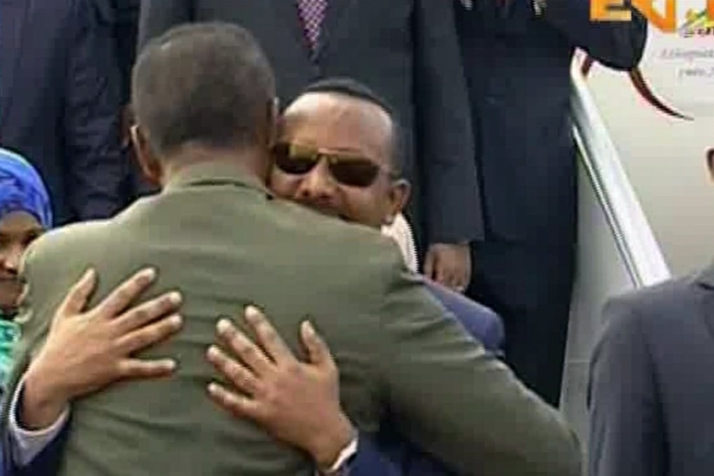 In this grab taken from video provided by ERITV, Ethiopia's Prime Minister Abiy Ahmed (in sunglasses) embraces Erirea's President Isaias Afewerki after disembarks his plane, in Asmara, Eritrea, on Sunday. Photo: ERITV via AP