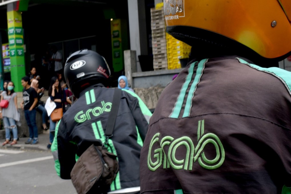 Grab bike riders wait for passengers outside a commuter train station in Jakarta on June 13, 2018. Photo: AFP