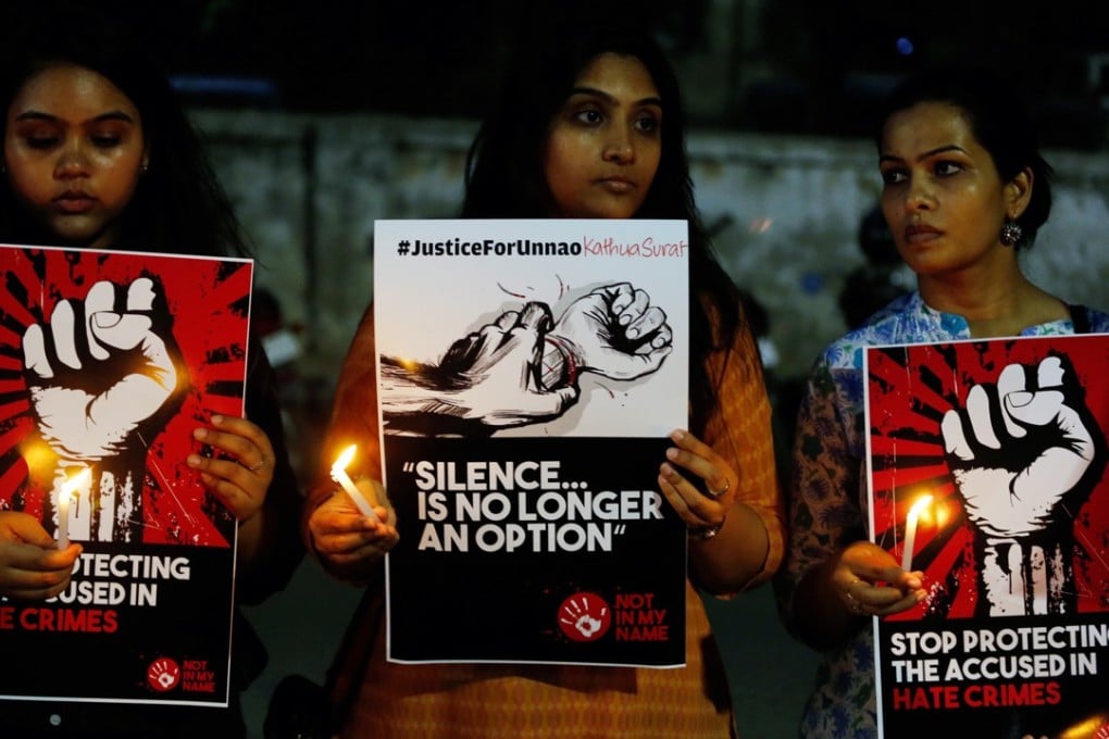 Women hold candles and placards during a protest in Ahmadabad, India, in April. Photo: AP