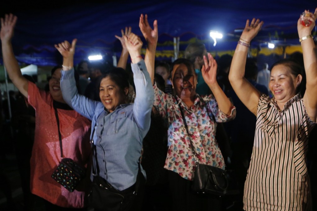 People celebrate after divers evacuate some of the boys and their coach trapped at Tham Luang cave in northern Thailand on Tuesday. Photo: AP