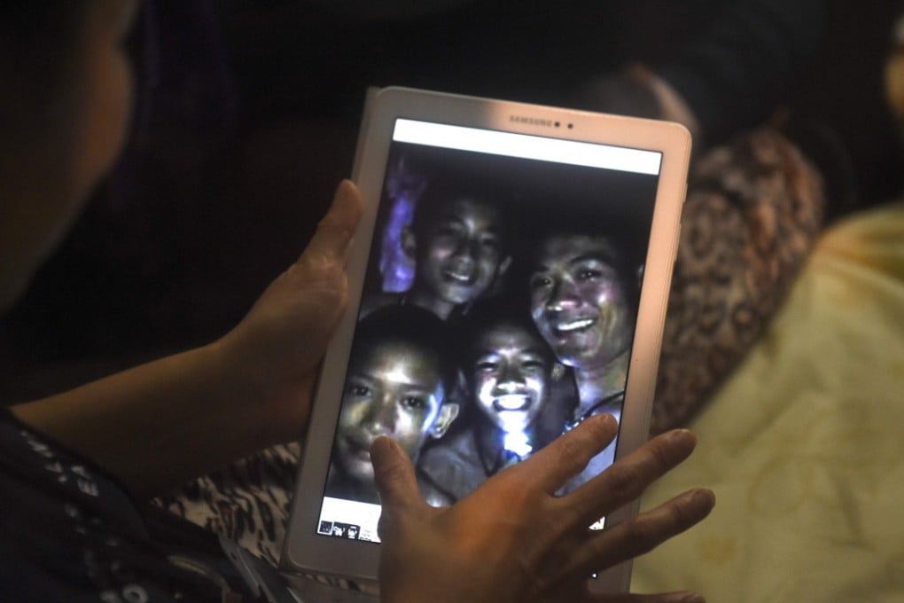 A family member shows a picture of the boys after divers found them in the cave. Photo: AFP