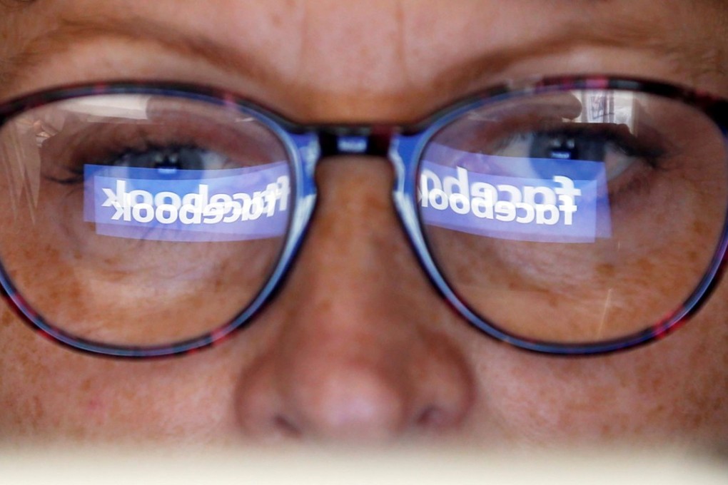 The Facebook logo is reflected on a user's glasses. Photo: Reuters