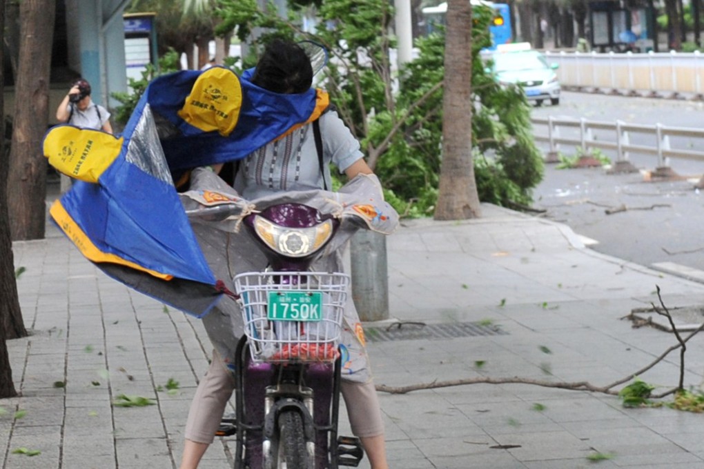 A woman riding an electric bicycle braces herself against strong wind brought by Typhoon Maria on a street in Fuzhou, Fujian province, on Wednesday. Photo: Reuters