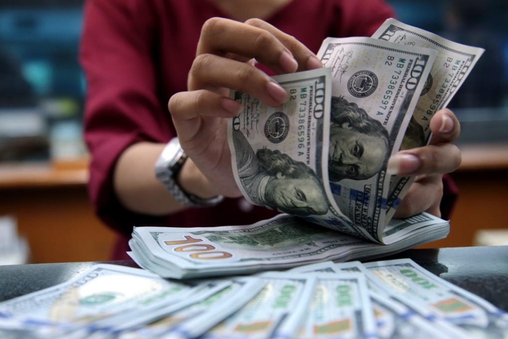 An Indonesian employee counts US dollar banknotes at a money changer in Jakarta, Indonesia, on May 8. The strengthening US dollar over the past month hit emerging market currencies hard. Photo: EPA-EFE