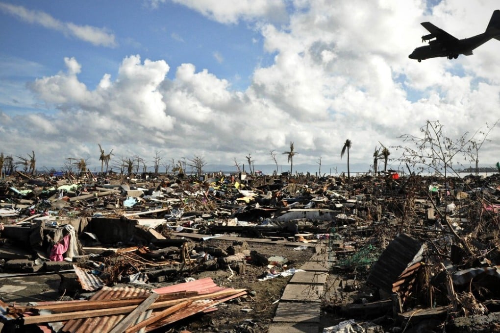 A military aircraft passes over a destroyed area of Tacloban City, the Philippines, after Typhoon Haiyan ripped through it in 2013. Photo: Alamy