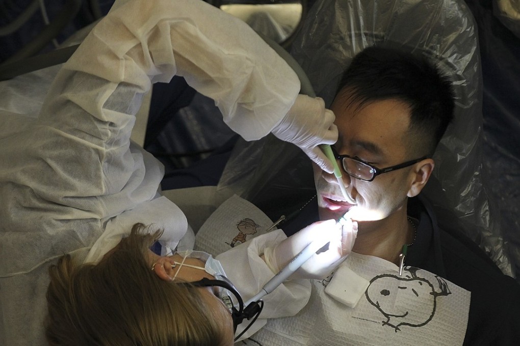 A dentist performs a procedure during a free clinic in Oakland, California, in March 2012. Investors should take their cue from dental advice on regular maintenance and tailor their portfolios to the changing market conditions. Photo: Getty Images/AFP