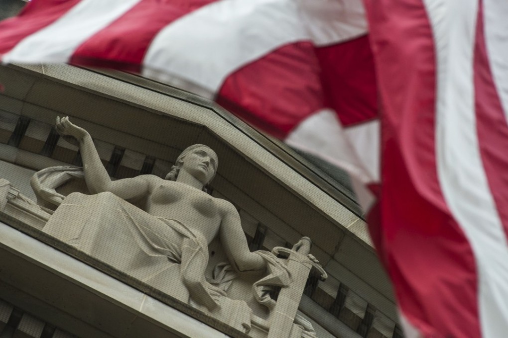 The US national flag flies over a statue on the Department of Justice in Washington, DC. Photo: AFP