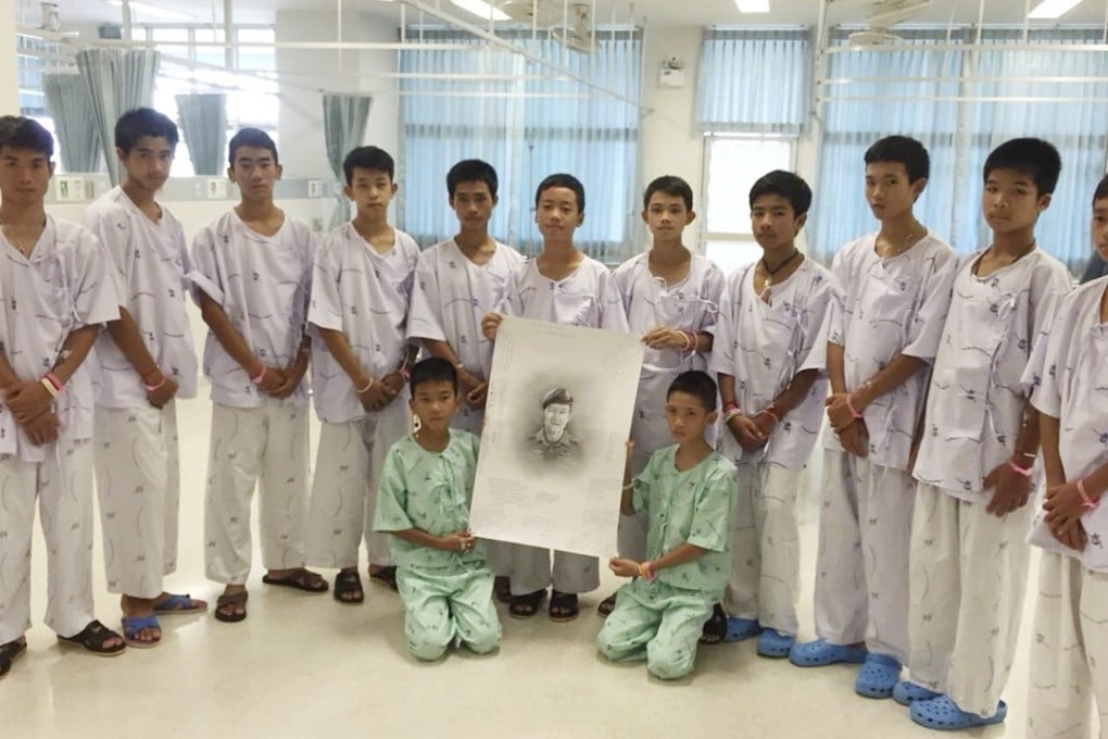 The rescued players with a sketch of the Thai Navy Seal diver who died while trying to rescue them. Photo: AP