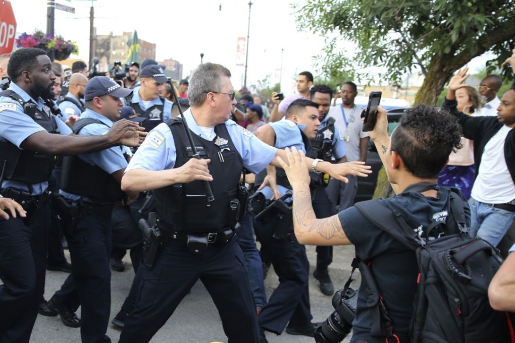 Officers scuffle with an angry crowd after a shooting involving police in Chicago. Photo: AP