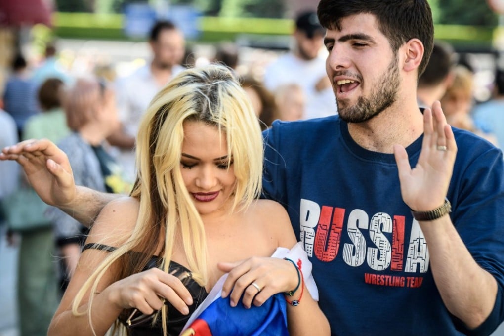 A Russian woman poses for a photo with a foreign fan on Nikolskaya street in Moscow. A petition has been launched demanding an apology from the tabloid newspaper that published a controversial article, describing Russian women as ‘whores’ for flirting with foreign fans during the World Cup. Photo: AFP
