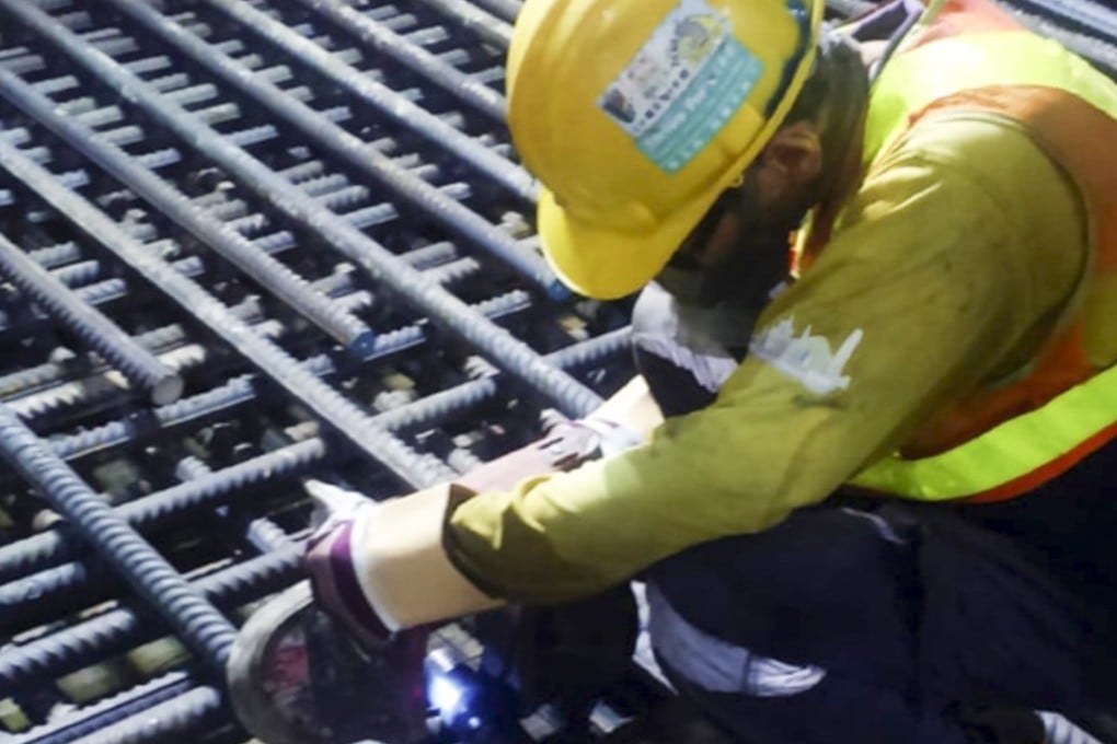 A worker wearing safety gear bearing the logo of Leighton Contractors (Asia) works on a construction site for Hung Hom station for the new Sha Tin to Central line. Photo: Handout