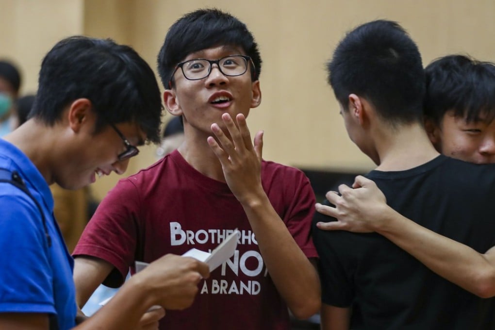 Queen’s College students review their score on the Diploma of Secondary Education exam this month. fewer students – 59,000 – sat for the exam this year, Photo: Nora Tam/SCMP