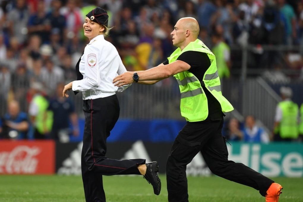 A member of Russian protest group Pussy Riot is grabbed by security after storming the pitch at the World Cup final between France and Croatia yesterday. Photo: AFP