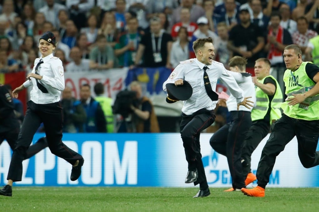 Stewards remove pitch invaders during the Russia 2018 World Cup final football match between France and Croatia at the Luzhniki Stadium in Moscow on Sunday. Photo: AFP