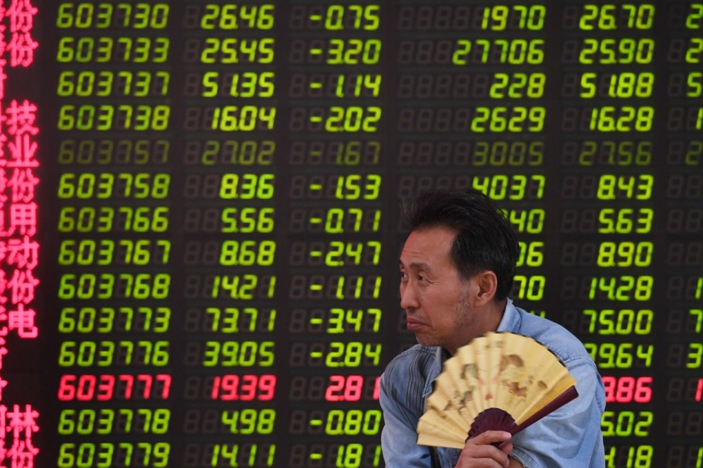 A man at a securities company in Beijing on July 4, 2018. Contrary to global conventions, China’s stock exchange illustrates gains and advances in red, using the green colour to denote losses and declines. Photo: AFP