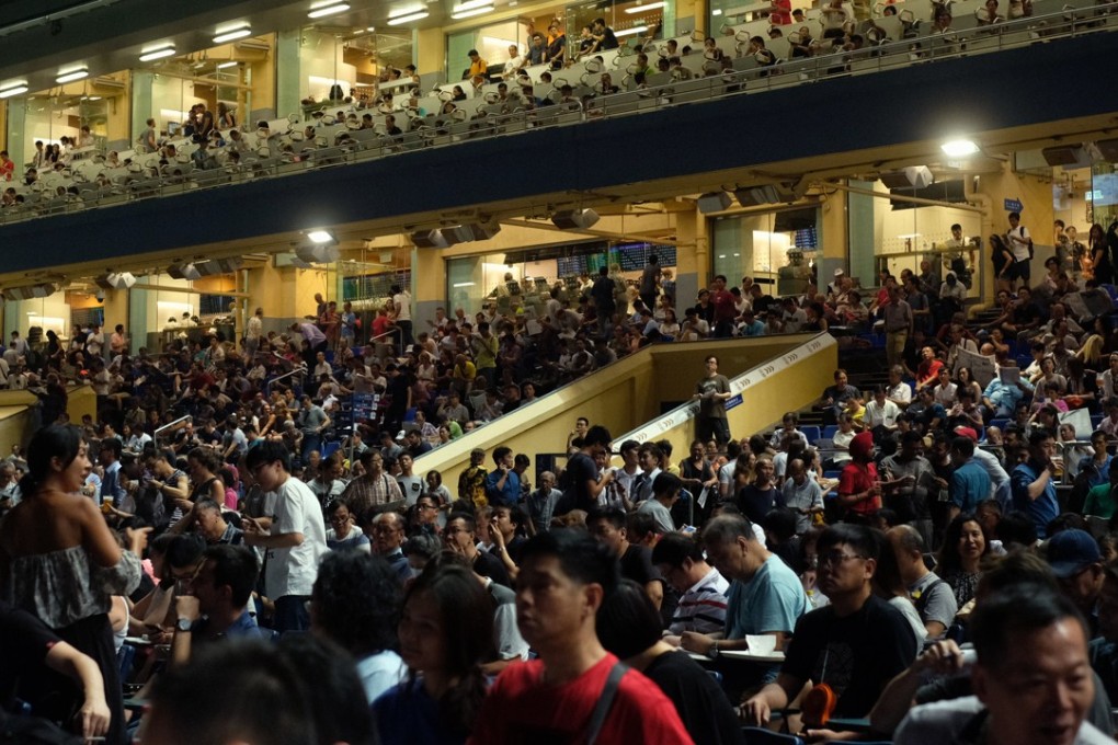 Spectators at Happy Valley watch the horse racing on the last day of the season. Photo: Tory Ho