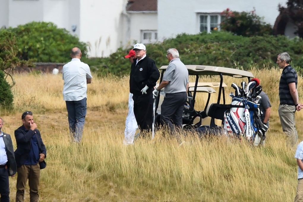 Security agents protect US President Donald Trump as he plays a round of golf on the Ailsa course at Trump Turnberry, the luxury golf resort Trump owns. Photo: AFP