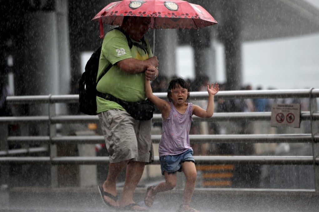 Pedestrians in the rain at the Tsim Sha Tsui harbourfront. Photo: Edward Wong