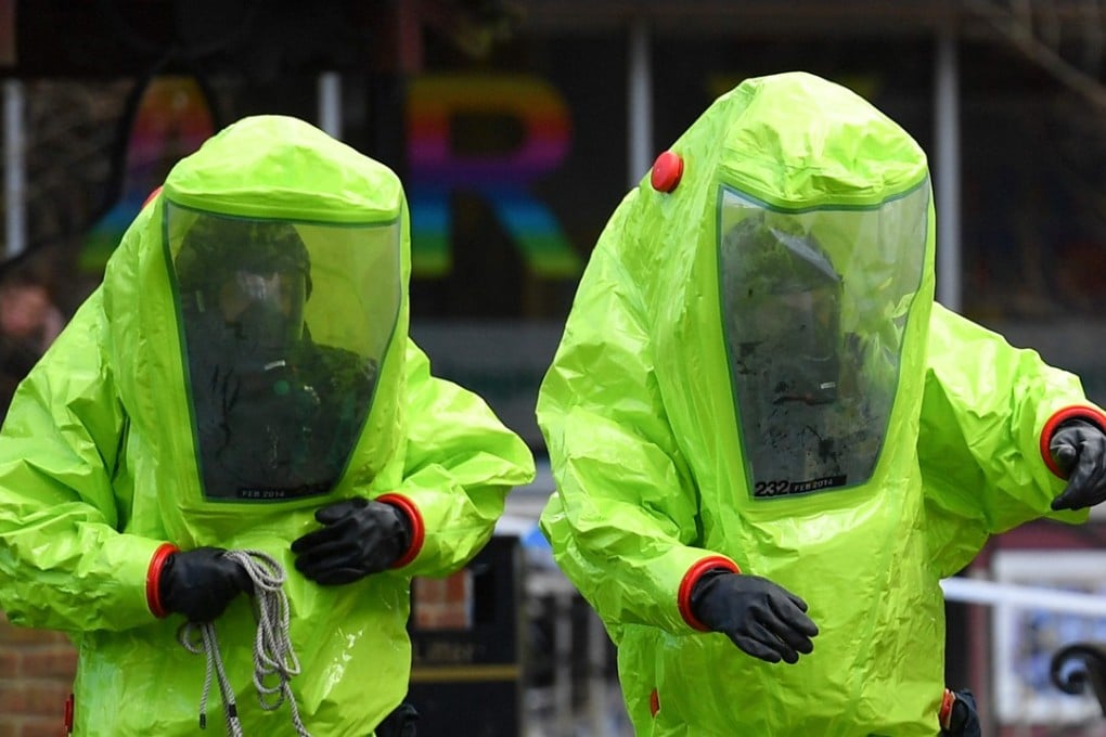 Members of the emergency services in green biohazard suits work to afix the tent over the bench where Sergei and Yulia Skripal were found on March 4 in critical condition in Salisbury, southern England, on March 8. Photo: AFP