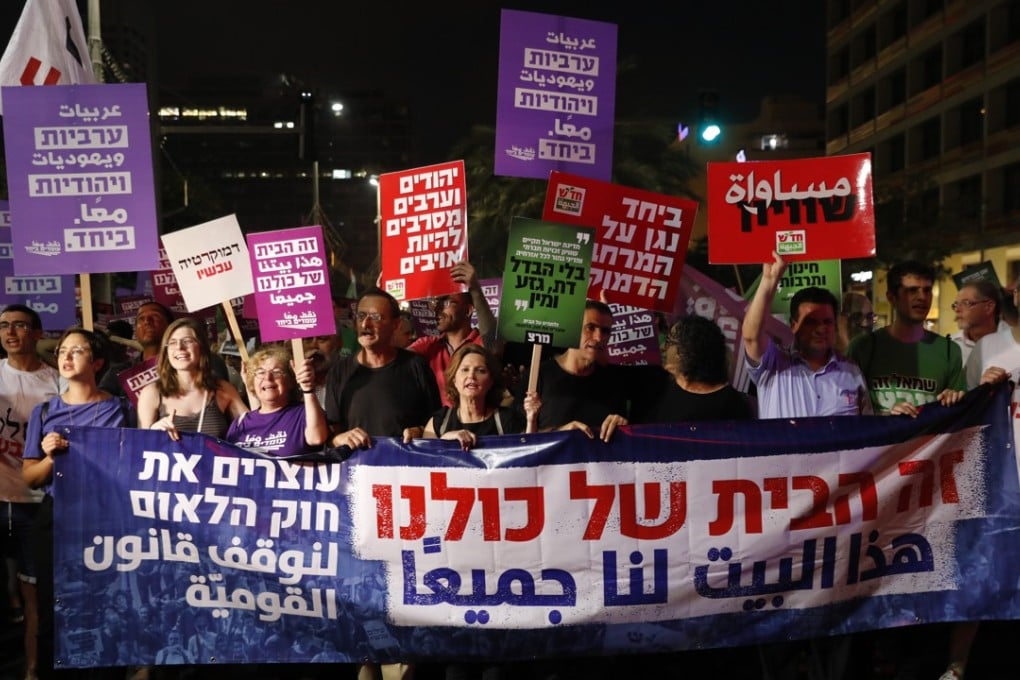 Israelis hold placards reading “This house belongs to all of us” during a protest against the controversial Nationality Bill. Photo: EPA