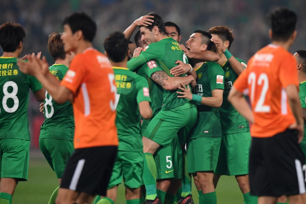 Beijing Guoan players celebrate after beating local rivals Renhe at the Workers’ Stadium. Photo: Xinhua