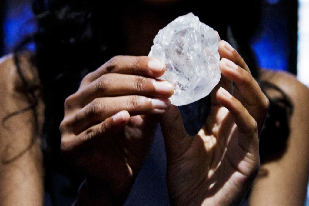 A model holds up the 1,109-carat Lesedi la Rona diamond, reportedly the largest gem-quality rough diamond to be discovered in over 100 years, during an auction preview at Sotheby's auction house in New York in May 2016. Photo: EPA