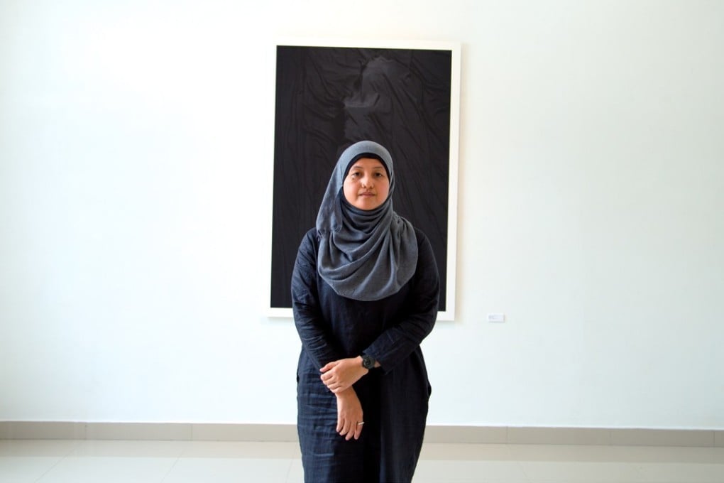 28-year-old Ampannee Satoh stands with one of her pieces from “The Light” in the background. Photo: Muhaimin E-taela