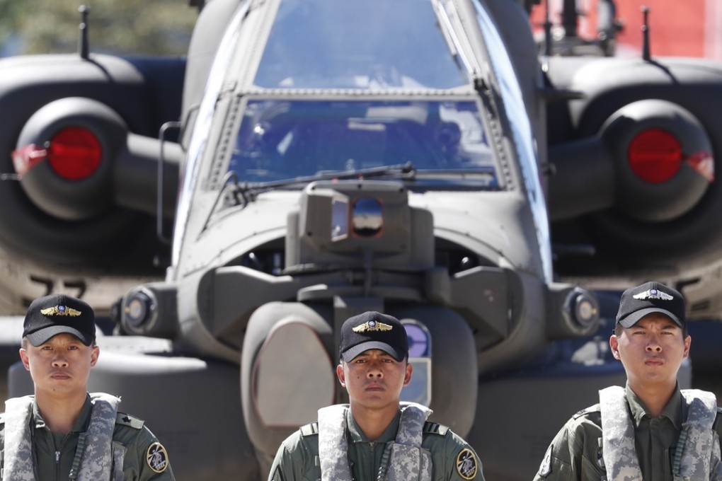 Taiwanese soldiers stand guard in front of US-made Apache attack helicopters on Wednesday. Photo: EPA