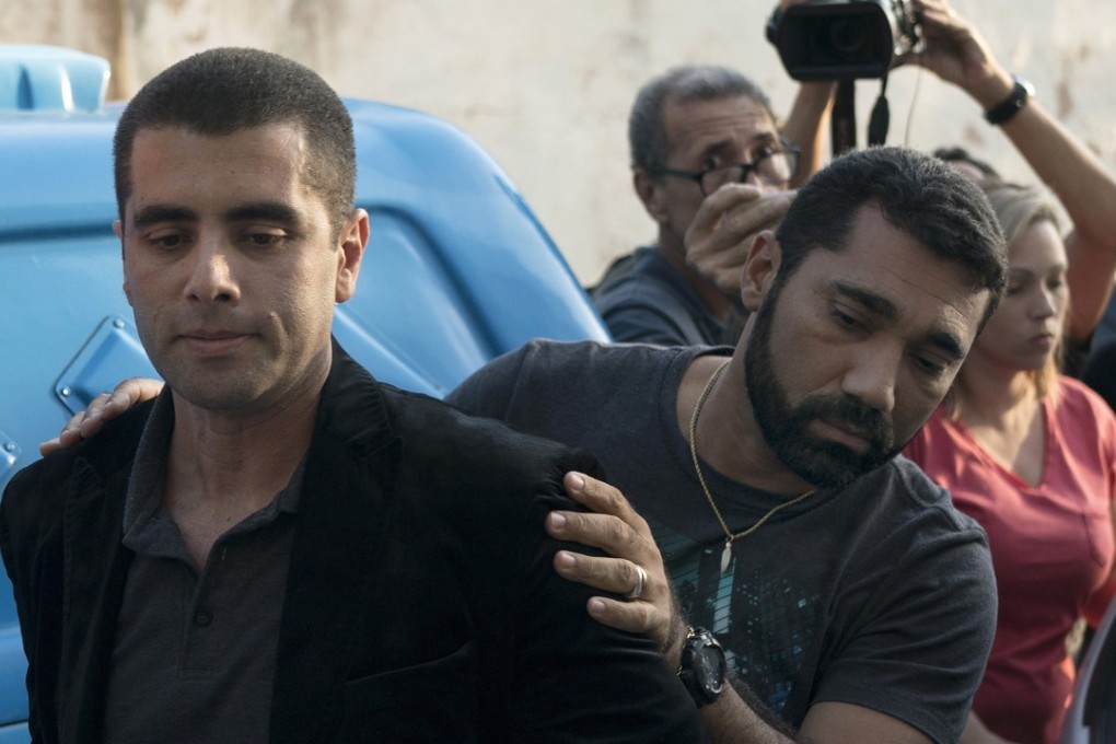Brazilian surgeon Dr Denis Furtado is escorted by police after his arrest in Rio de Janeiro, Brazil, on Thursday. Photo: AP