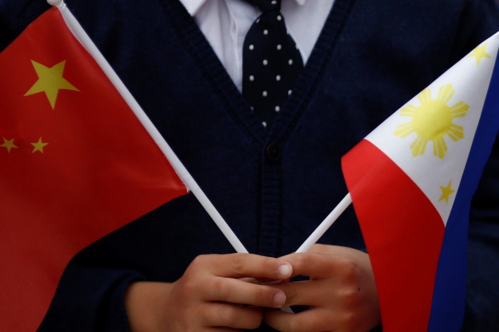 A child holds national flags of China and the Philippines before Philippine President Rodrigo Duterte and China's President Xi Jinping attend a welcoming ceremony in Beijing in October 2016. Photo: Reuters