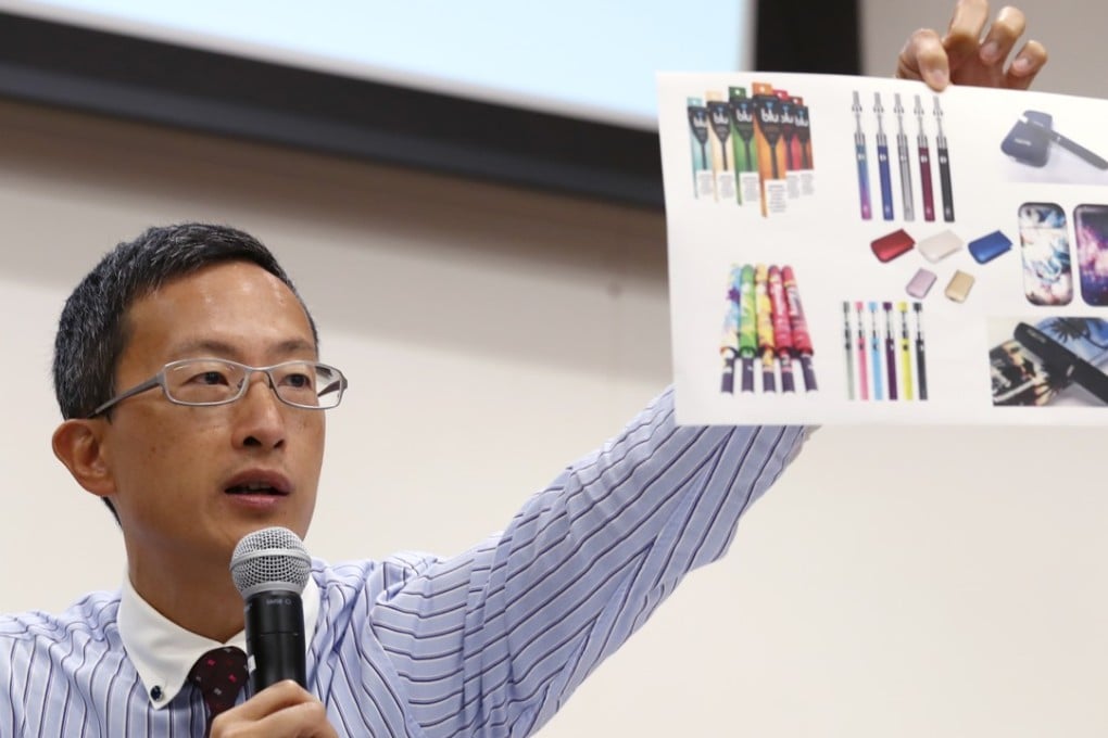 Dr David Lam Tzit-yuen, honorary secretary of the Hong Kong Medical Association, displays pictures of different types of electronic cigarettes, during a press conference calling for a total ban on e-cigarettes and other new tobacco products, in Wong Chuk Hang on June 19. Photo: Nora Tam