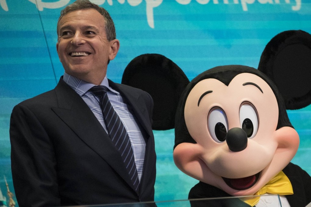 Bob Iger, CEO and chairman of the Walt Disney Company, and Mickey Mouse ring the bell at the New York Stock Exchange in November 2017. Photo: Getty Images