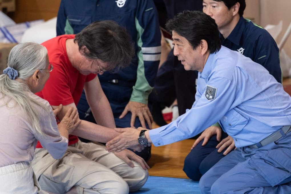 Japan's Prime Minister Shinzo Abe visits a shelter for people affected by the recent flooding in Mabi, Okayama prefecture on July 11. He is expected to announce his candidacy for the LDP presidency. Photo: AFP