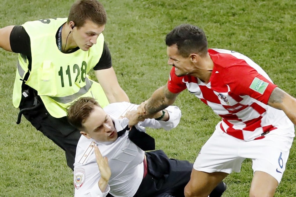 Dejan Lovren of Croatia tries to take an intruder out of the field during the second half of the World Cup final against France at the Luzhniki Stadium in Moscow. Photo: Kyodo