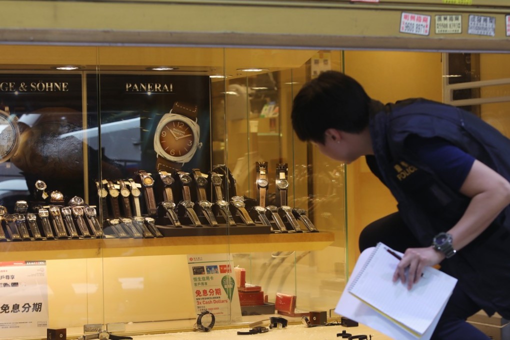 An officer inspects the crime scene at VIP Watch & Jewellery store on Haiphong Road in Tsim Sha Tsui. Photo: Sam Tsang