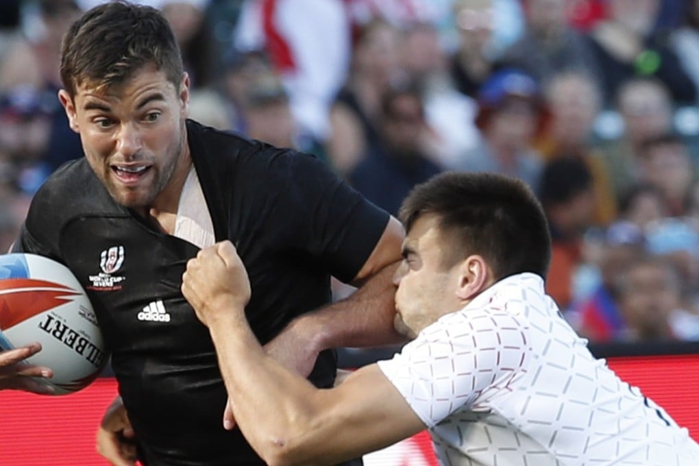 Andrew Knewstubb (left) of New Zealand holds off England’s William Muir during the Rugby World Cup Sevens final. Photo: EPA