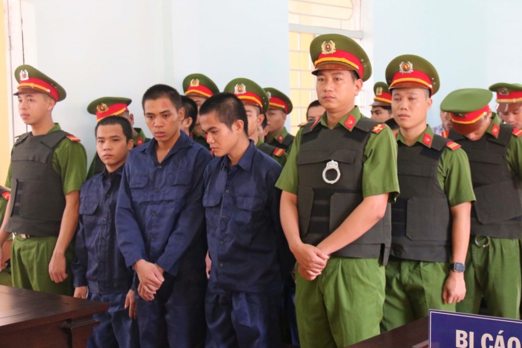 Detained protesters flanked by police stand before a court in Binh Thuan, southern Vietnam on July 23, 2018 during their conviction for taking part in a violent protest last June. Photo: AFP