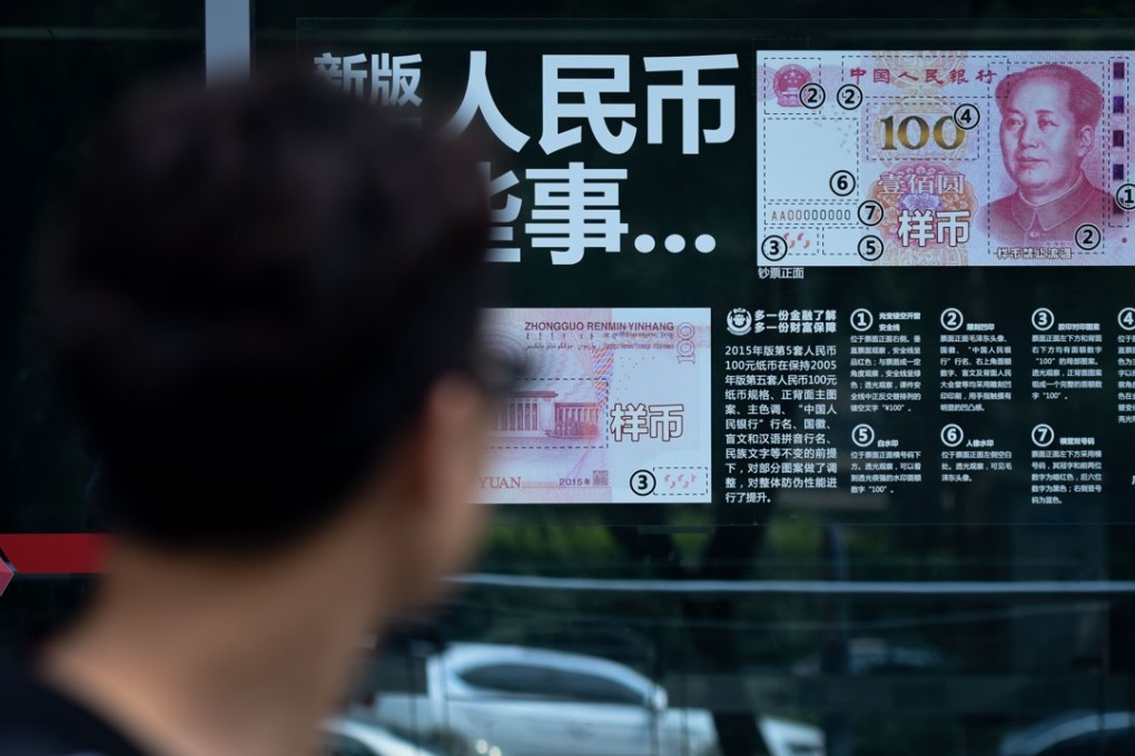 A man looks at information posted on a bank door showing how to distinguish real banknotes in Beijing on July 20. China’s yuan has continued its steady decline, defying US President Donald Trump’s warning over the dollar’s rise and providing Beijing with a buffer against punitive trade tariffs imposed by Washington. Photo: AFP