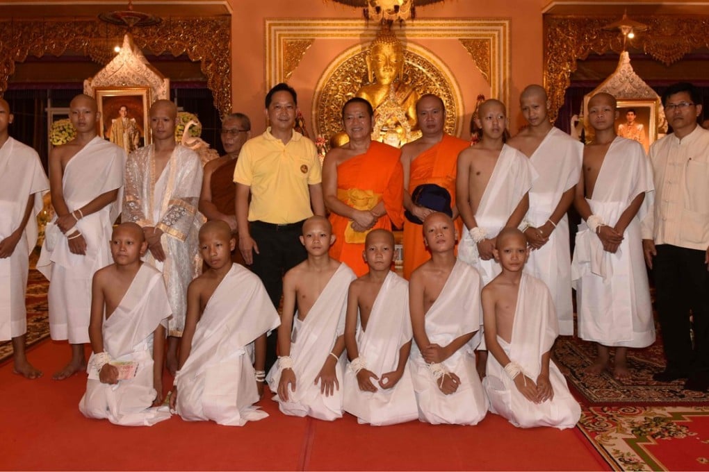 The rescued Thai boys and their coach wearing white robes and posing with Buddhist monks at the Phra That Doi Wao Buddhist temple in the Mae Sai district of Chiang Rai province on July 24, 2018. Photo: AFP