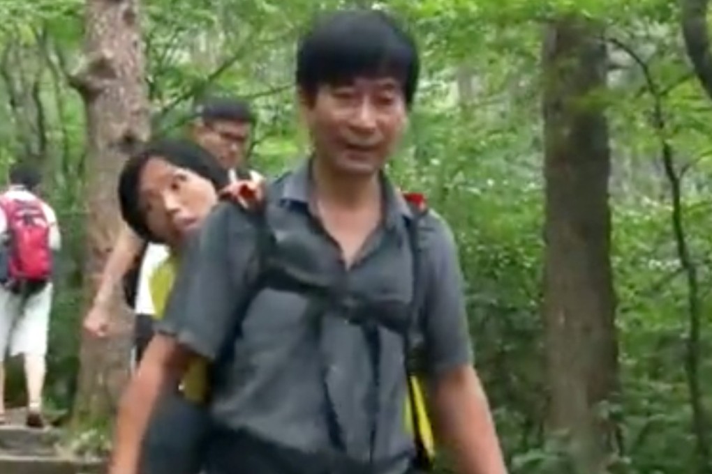 A husband carried his wife, who suffers from motor neurone disease, on his back up one of China’s most famous mountains. Photo: Pear Video