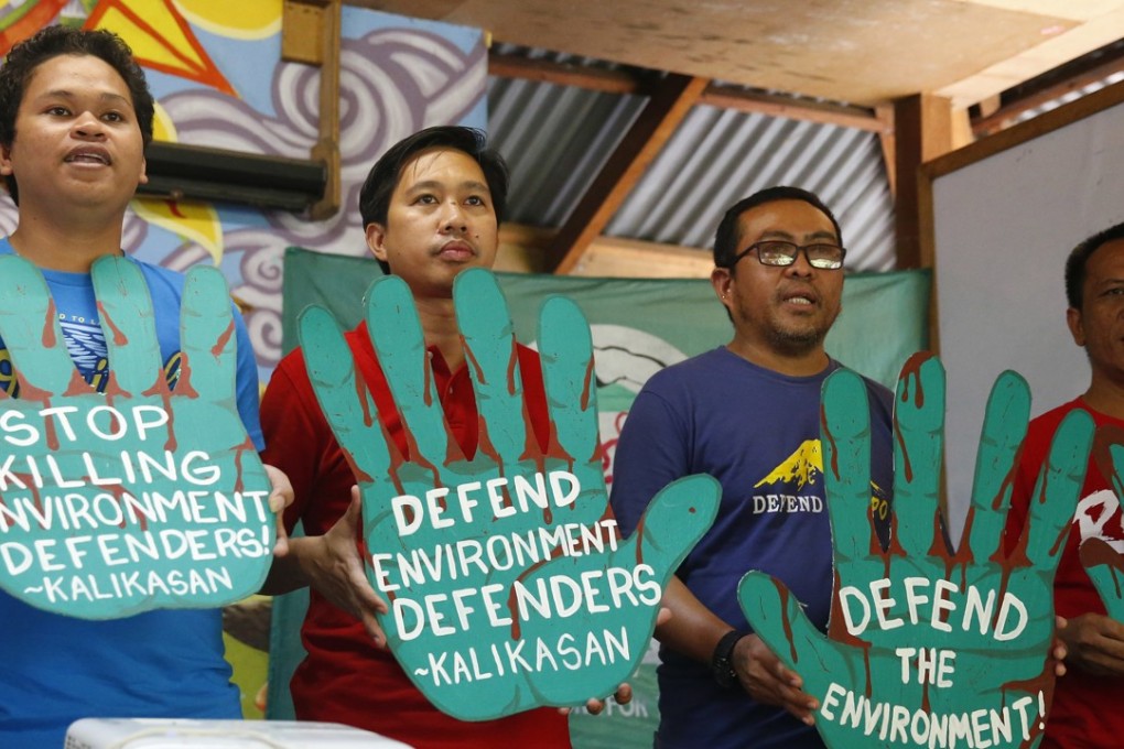 Members of environmental activist group ‘Kalikasan People’s Network for the Environment’ display hand cutouts with their messages. Photo: AP