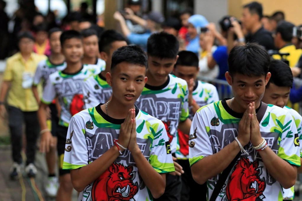 The 12 “Wild Boars” and their soccer coach (right), who became trapped in a flooded cave on June 23, arrive for a news conference in Chiang Rai, Thailand, on July 18. Photo: Reuters