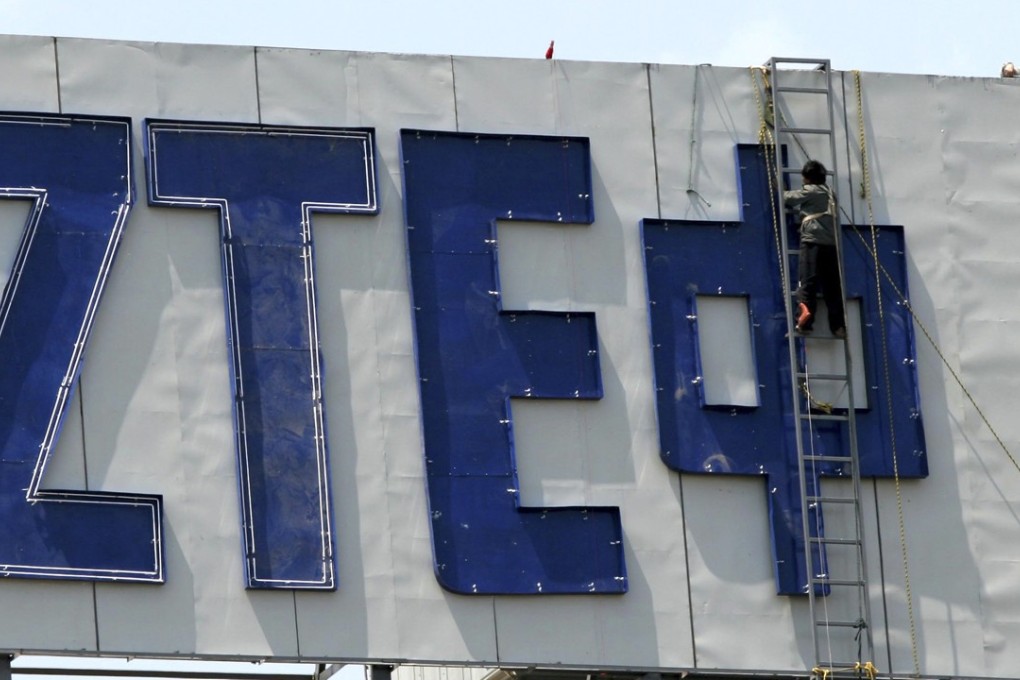 Workers are seen on the ZTE logo in 2017. Photo: Chinatopix via AP