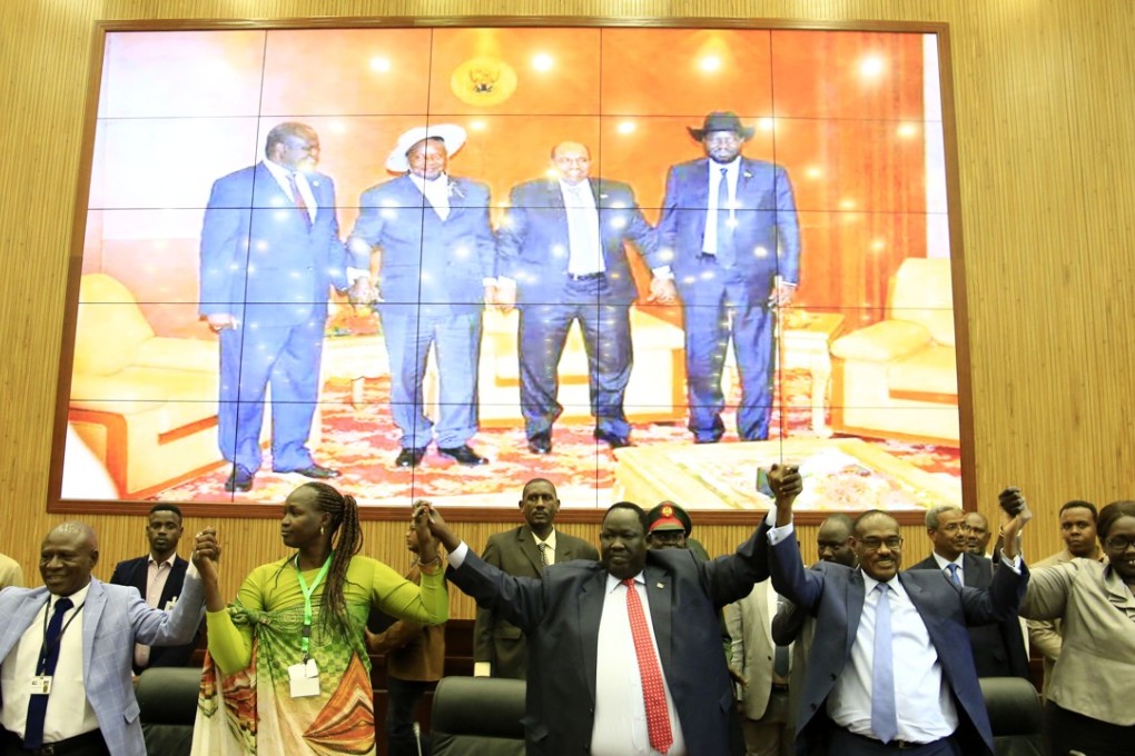 Representatives of South Sudan’s conflicting parties hold their hands after signing an agreement on power-sharing and governance in Khartoum. Photo: Xinhua