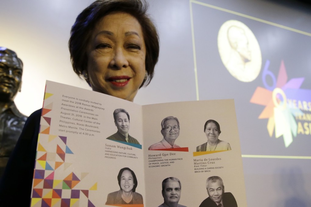 Ramon Magsaysay Award Foundation President Carmencita Abella poses with pictures of this year’s awardees. Photo: AP